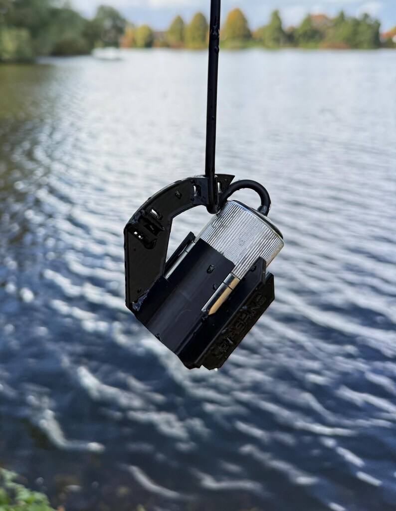 Underwater camera in the black anti-spinner hanging at an angle above the water, cable looped through the clip on the arm