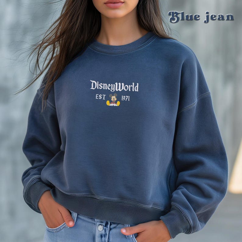 May include: A blue sweatshirt with a white graphic of Mickey Mouse and the text "Disney World Est 1971".