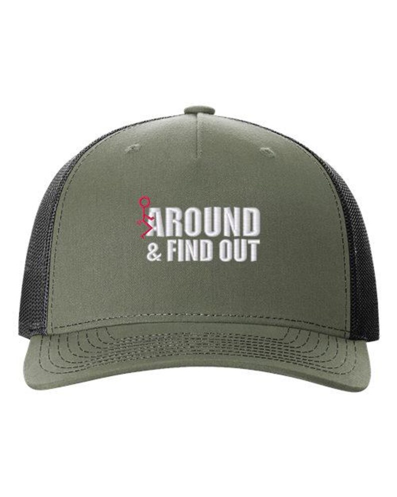 Pu&ograve; includere: Un cappello da camionista verde e nero con il testo "AROUND & FIND OUT" ricamato in bianco sul davanti. Il testo &egrave; accompagnato da un omino rosso con le braccia alzate.