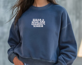 Pode incluir: Uma camisa de moletom azul com o texto "Sugar & Spice and Reproductive Rights" em letras brancas.