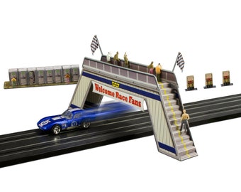 May include: A blue race car speeds under a bridge with a sign that reads "Welcome Race Fans". The bridge has a checkered flag and a railing with miniature figures standing on it. There are also miniature figures standing on the stairs of the bridge.
