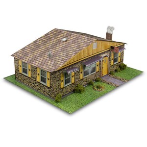 May include: A paper model of a brown and yellow suburban house with a brown shingled roof, a chimney, and a small American flag on the side. The house has a stone facade and windows with yellow shutters and black stars.
