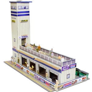 May include: A model of a race track building with a tower that says "Earl's" and "Welcome Race Fans". The building has several garage doors and a balcony with miniature people standing on it. The building is made of cardboard and has a white and blue color scheme.