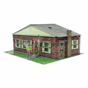 May include: A paper model of a brick house with a green roof and a small American flag hanging on the front porch. The house has two windows on each side and a door with a number "1448" on it. Two figures stand in front of the house.