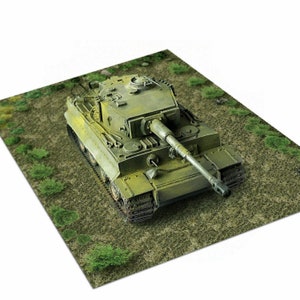 May include: A green military tank model with a long barrel gun, sitting on a green grassy surface.