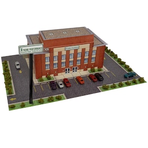 Puede incluir: Un edificio de ladrillo rojo con un letrero verde que dice "XTREME PERFORMANCE Automotive Engine Design and Testing". El edificio tiene un estacionamiento con varios autos en frente.