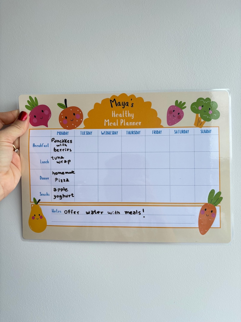 Puede incluir: Un planificador de comidas beige con el texto "Maya's Healthy Meal Planner" y un horario semanal. El planificador presenta ilustraciones de frutas y verduras. El horario incluye secciones de desayuno, almuerzo, cena y meriendas.