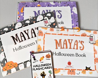 May include: A set of Halloween-themed flashcards featuring images of a black cat, treat, pumpkin, ghost, haunted house, and zombie. The flashcards are labelled with the name "Maya's Halloween Book" and "LearnBug Early Years Resources".