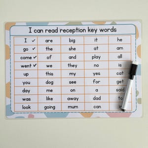 May include: A white laminated learning board with the text "I can read reception key words" and a grid of sight words. A black and white dry-erase marker rests on the right side of the board. The board has a pastel color design.