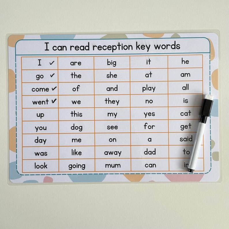 May include: A white laminated learning board with the text "I can read reception key words" and a grid of sight words. A black and white dry-erase marker rests on the right side of the board. The board has a pastel color design.