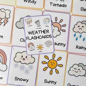 May include: A set of weather flashcards featuring illustrated weather conditions. The central card displays "WEATHER FLASHCARDS" with weather icons and labels. Other cards show "Windy", "Tornado", "Sunny", and "Snowy". The cards have a white background with a purple border.