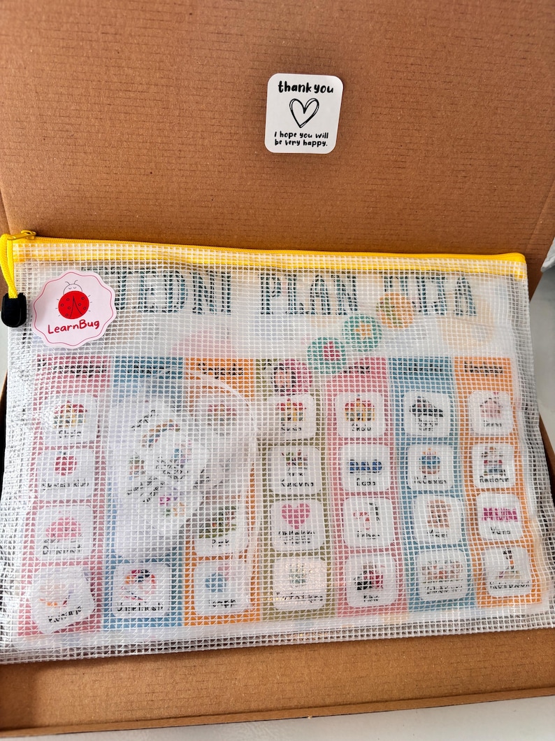 Op de afbeelding: Een witte mesh-ritszak met een gele rits en een gekleurde bedrukte kaart erin. De kaart heeft een raster van gekleurde vierkanten met afbeeldingen en tekst. De tekst op de kaart zegt "EDNI PLAN XTRA". De tas heeft een klein rood insectenlogo met de tekst "LearnBug" erop.