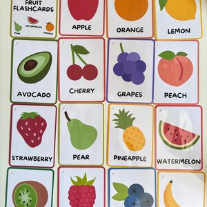 Pode incluir: Um conjunto de cart&otilde;es de mem&oacute;ria de frutas coloridas. Cada cart&atilde;o apresenta uma ilustra&ccedil;&atilde;o de uma fruta diferente e seu nome, incluindo ma&ccedil;&atilde;, laranja, lim&atilde;o, abacate, cereja, uvas, p&ecirc;ssego, morango, pera, abacaxi, melancia, kiwi, framboesa, mirtilos e banana.