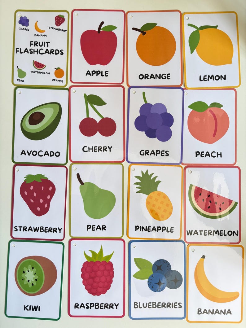 Pode incluir: Um conjunto de cart&otilde;es de mem&oacute;ria de frutas coloridas. Cada cart&atilde;o apresenta uma ilustra&ccedil;&atilde;o de uma fruta diferente e seu nome, incluindo ma&ccedil;&atilde;, laranja, lim&atilde;o, abacate, cereja, uvas, p&ecirc;ssego, morango, pera, abacaxi, melancia, kiwi, framboesa, mirtilos e banana.