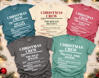 May include: Five Comfort Colors t-shirts in blue jean, ivory, crimson, pepper, and chalky mint. Each shirt features white or red text reading CHRISTMAS CREW, followed by fields for Name, Role, Department, and Approved By: Santa.