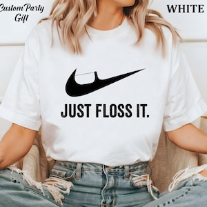 a woman wearing a t - shirt that says just floss it