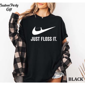a woman wearing a black shirt that says just floss it