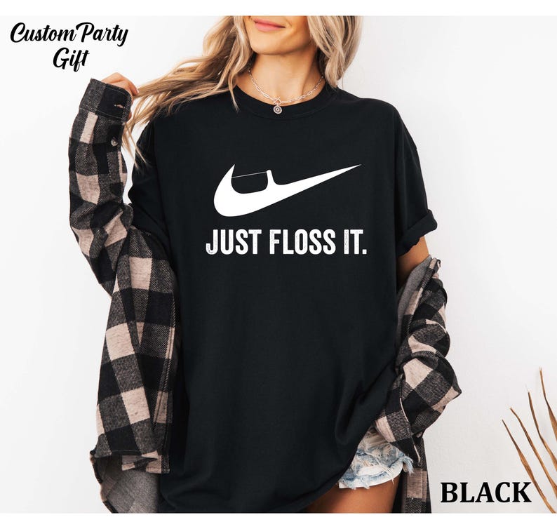 a woman wearing a black shirt that says just floss it