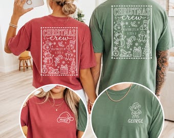 May include: A crimson t-shirt and a moss green t-shirt featuring a white back graphic with the text CHRISTMAS crew NEW YORK CITY, NY 2026 and holiday icons. The front of the crimson shirt shows a Santa hat with the name MARY, while the moss shirt shows a Santa figure with the name GEORGE.