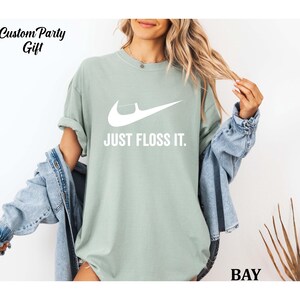 a woman wearing a t - shirt that says just floss it