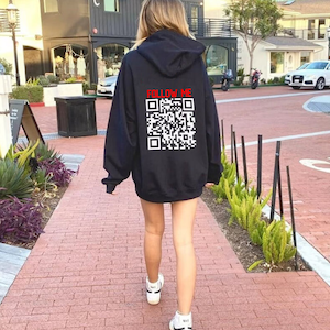 Puede incluir: Sudadera con capucha negra con el texto "FOLLOW ME" en rojo y un código QR blanco en la parte posterior.