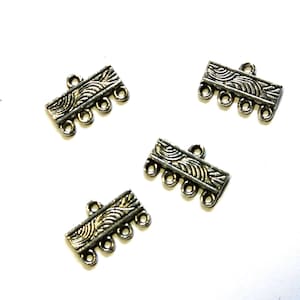 May include: Four silver-toned metal jewelry connectors. Each connector has a rectangular shape with a decorative wave pattern and three small loops on the bottom edge. A single loop is at the top.