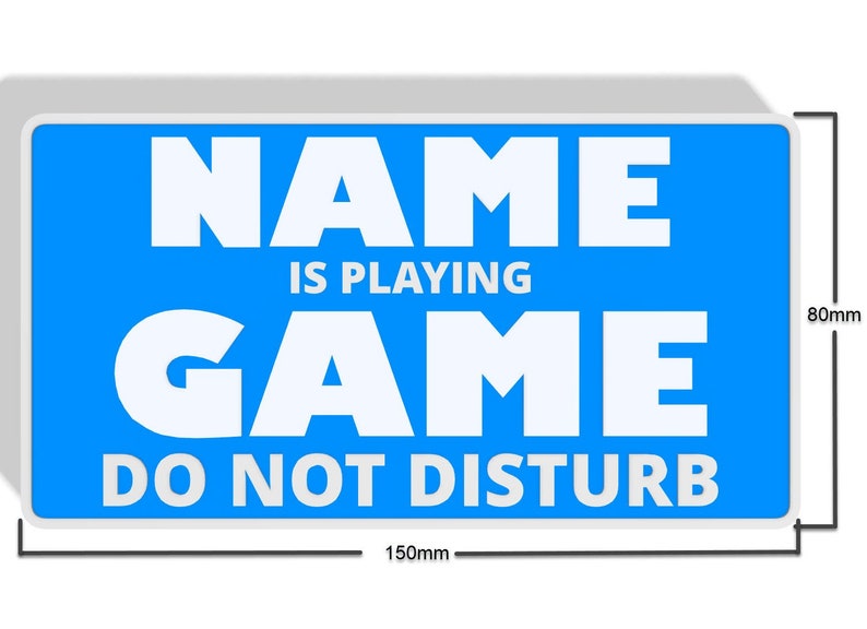May include: A blue sign with white text that reads "NAME IS PLAYING GAME DO NOT DISTURB". The sign is 150mm wide and 80mm tall.