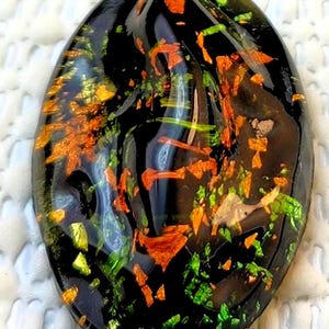 Vintage Glass Cabochon with Foil and Molded Glass Design on Black Glass Background