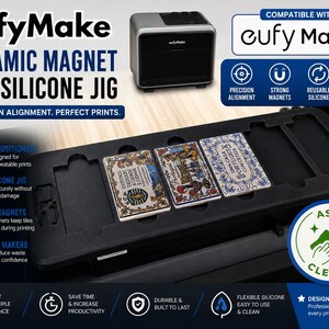 May include: A black silicone jig for eufyMake ceramic magnet tiles, featuring multiple rectangular slots for precision alignment. The device includes strong magnets to hold tiles securely during printing, with text labels highlighting features like reusable silicone and easy cleaning.