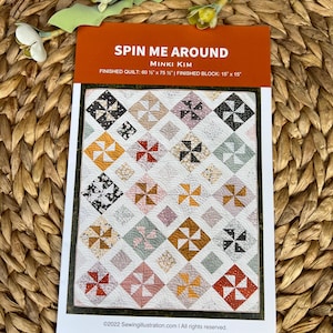 May include: A quilt pattern titled "Spin Me Around" by Minki Kim. The pattern features a colorful pinwheel design with squares and diamonds. The finished quilt size is 60.5" x 75.5", and the finished block is 15" x 15".