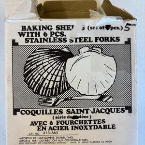May include: A cardboard box featuring the text "BAKING SHE! WITH 6 PCS. STAINLESS STEEL FORKS" and an illustration of two scallop shells. The box also has the text "COQUILLES SAINT-JACQUES AVEC 6 FOURCHETTES EN ACIER INOXYDABLE".
