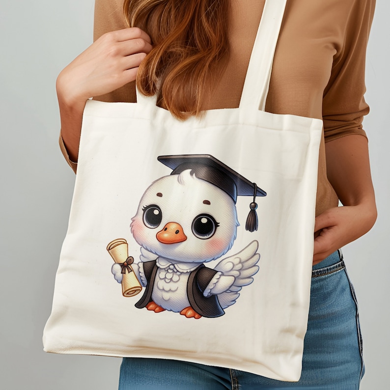 May include: A white tote bag with a cartoon illustration of a duck wearing a graduation cap and holding a diploma. The duck is wearing a black graduation gown. The bag is made of canvas and has a white background.