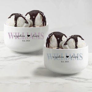 May include: Two white ceramic bowls filled with scoops of vanilla ice cream topped with chocolate syrup. Each bowl features the text "WILLIAMS" in large letters, "sophia &hearts; luis" in script, and "Est. 2024" printed in black ink on the front.