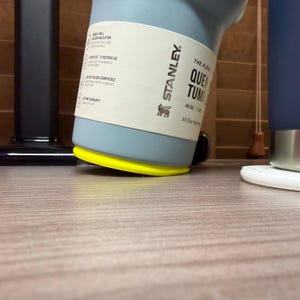 K&ouml;nnte beinhalten: Eine wei&szlig;e Keramik-Tasse mit schwarzem Henkel und dem Text "But First, Coffee" in schwarzer, fetter Schrift. Die Tasse steht auf einer wei&szlig;en Oberfl&auml;che.