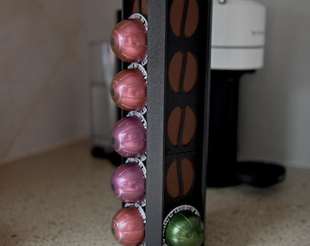 May include: A black coffee pod holder with six coffee pods. The pods are in a vertical row and are a mix of pink and green.