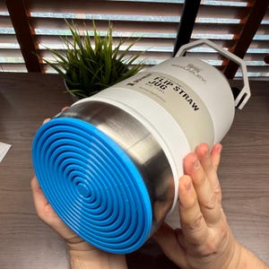 K&ouml;nnte beinhalten: Wei&szlig;er und Edelstahl Stanley Flip Straw Jug mit blauem Boden. Die Trinkflasche hat einen Griff und die Aufschrift "Flip Straw Jug" auf der Seite. F&uuml;r aktive Fl&uuml;ssigkeitszufuhr.