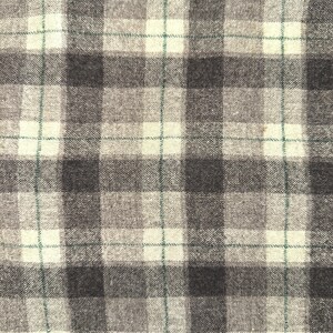 Puede incluir: Primer plano de una tela con un patr&oacute;n de cuadros. El dise&ntilde;o presenta una cuadr&iacute;cula de cuadrados grises oscuros, grises claros y blanquecinos alternados. Finas l&iacute;neas verdes intersectan el patr&oacute;n. La tela tiene una apariencia texturizada.