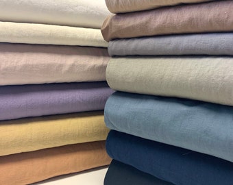 May include: A stack of fabric swatches in various colors, including white, beige, light pink, lavender, yellow, orange, blue, navy, and black. The fabric appears to be linen or cotton.