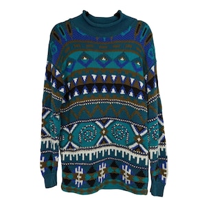 May include: A teal, blue, and brown patterned sweater with a mock neck. The sweater features geometric and tribal-inspired designs. The long-sleeved sweater is made of a knitted material and is isolated on a white background.