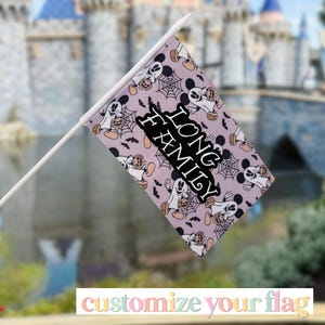 May include: A rectangular stroller flag featuring a light purple background with a repeating pattern of ghost-shaped Mickey Mouse icons holding pumpkins, black spiderwebs, and bats. The text LONG FAMILY is printed in black in the center.