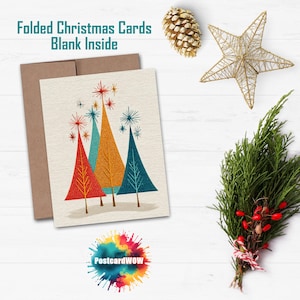 May include: Folded Christmas cards with blank inside. The card features a retro design of colourful Christmas trees in red, orange, and teal. The card is paired with a brown envelope. The image also includes a gold star, pine cone, and greenery.