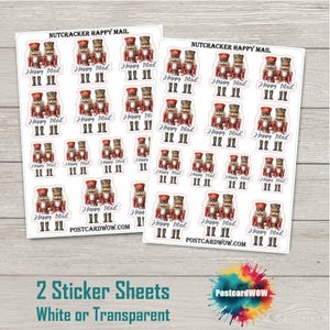 Puede incluir: Dos hojas de pegatinas con diseños de cascanueces. Cada pegatina muestra un soldado cascanueces con el texto "Happy Mail". Disponibles en opciones blancas o transparentes. También se ve la dirección del sitio web POSTCARDWOW.COM.