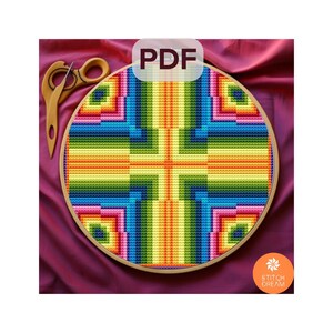 Puede incluir: Un colorido patrón de punto de cruz en un bastidor de madera. El diseño presenta un patrón geométrico con vibrantes colores del arcoíris. La imagen incluye unas tijeras de madera y un logotipo PDF.