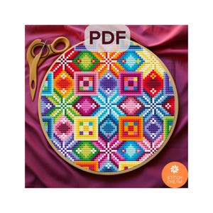 May include: A vibrant cross-stitch design displayed in a wooden embroidery hoop. The pattern showcases geometric shapes in a spectrum of colours, such as red, orange, yellow, green, blue, and purple. The image includes the text "PDF" and the logo "Stitch Dream".
