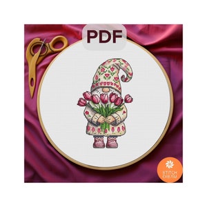 May include: Cross stitch pattern featuring a gnome holding a bouquet of pink tulips. The gnome is wearing a white hat with a floral pattern and a white sweater with a pink floral pattern. The pattern is in PDF format.