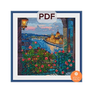 Puede incluir: Un patrón de punto de cruz de un paisaje urbano al anochecer, enmarcado en un borde azul. La escena incluye un río, edificios y un balcón con rosas rojas. La palabra "PDF" está en la parte superior central y el logotipo de Stitch Dream en la parte inferior derecha.