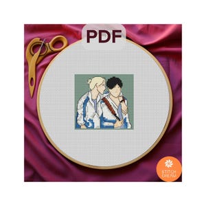 Puede incluir: Un patrón de punto de cruz con dos personas con chaquetas blancas y azules, sobre un fondo verde. El patrón se muestra en un aro de bordado de madera sobre una superficie de tela rosa. El texto "PDF" se muestra en un cuadro blanco sobre el aro.