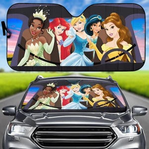 May include: Black car sunshade featuring a colorful illustration of several animated princesses. The princesses are depicted in their iconic dresses and are seated in a car. The sunshade is designed to fit a car's windshield.