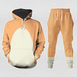 May include: A two-piece orange and white outfit, featuring a hooded sweatshirt and matching sweatpants. The sweatshirt has a large white oval shape on the front, and the hood is black. The sweatpants are orange with white cuffs.