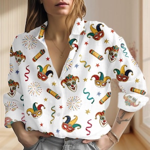 Könnte beinhalten: Weißes Hemd mit Knöpfen und einem sich wiederholenden Muster aus bunten Karnevalsmasken, Sternen, Feuerwerk und Luftschlangen. Das langärmlige Hemd hat einen Kragen und ist aus leichtem Stoff gefertigt.